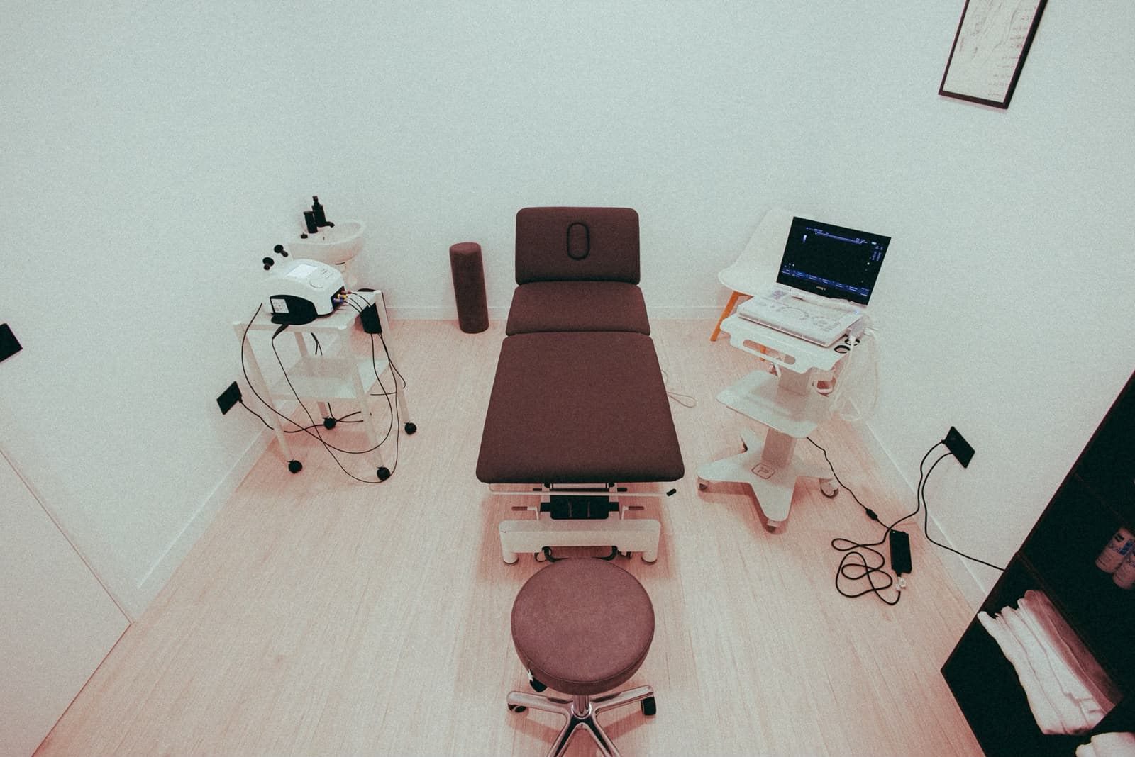 Vista de la sala de fisioterapia con camilla, ecógrafo y equipo de tratamiento.
